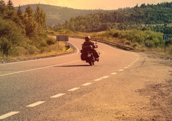 A Chattanooga motorcycle rider riding down the highway at sunset.