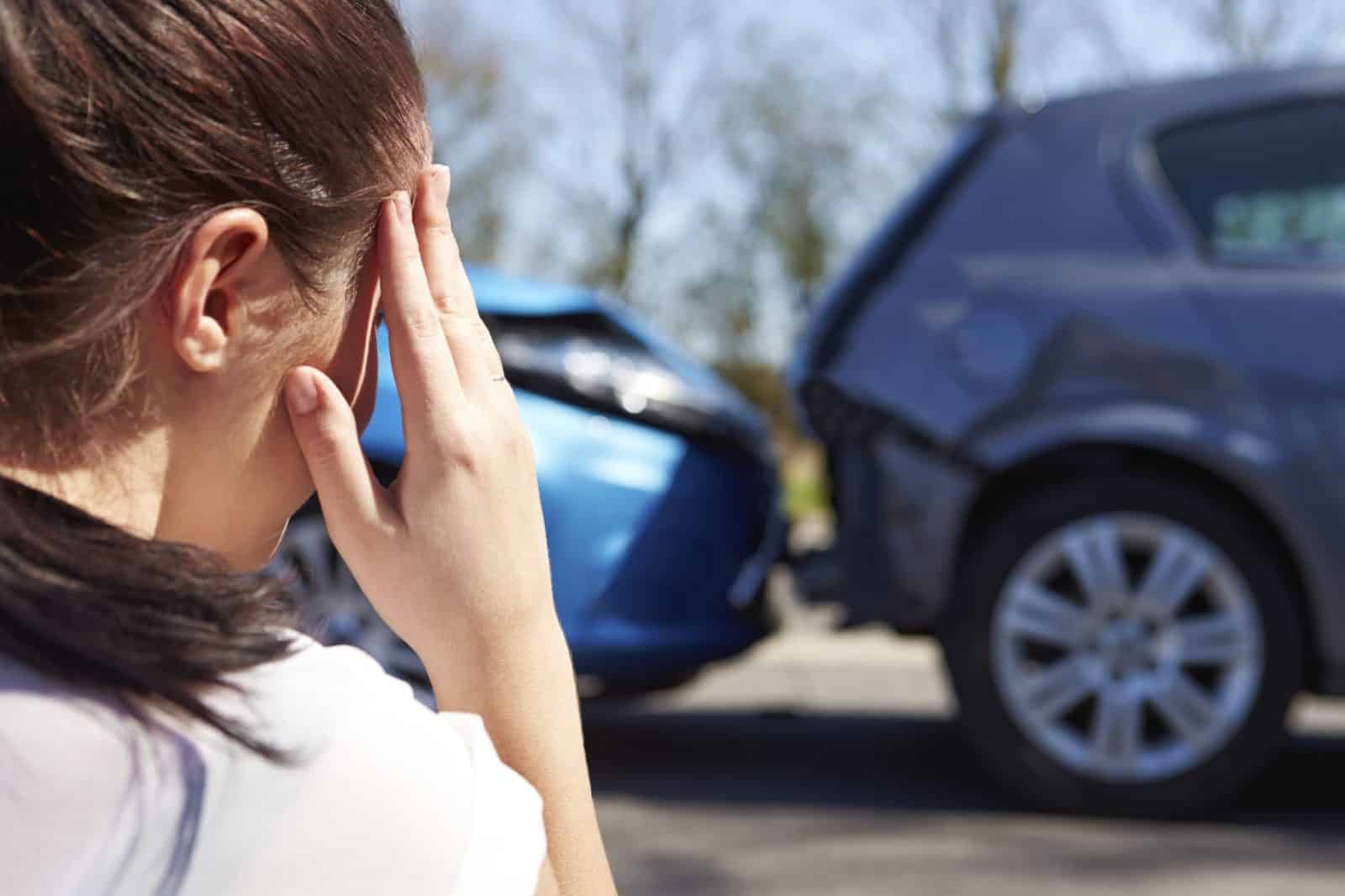 Distressed Woman Viewing Car Accident Scene Stock Photo