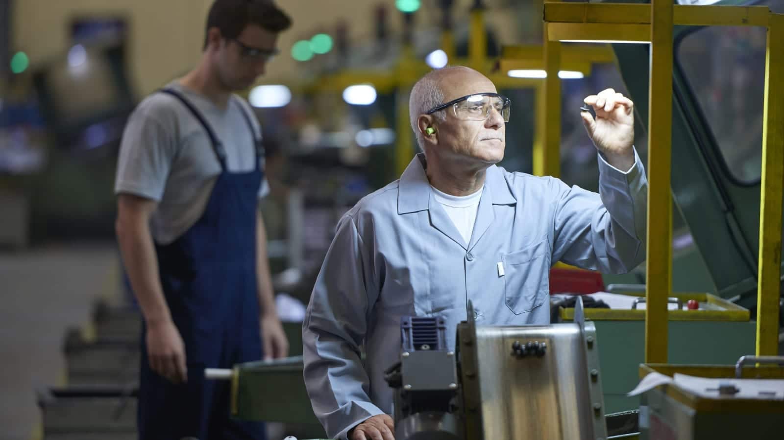 Blue Collar Worker Working Inside A Factory Stock Photo