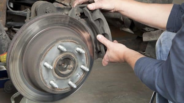 Mechanic Installing New Brakes On A Vehicle Stock Photo