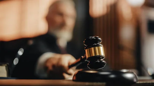 A judge brings their gavel down on a sound block during a personal injury court case.
