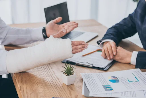 An individual with their arm in a cast is discussing their legal claim with a personal injury lawyer in Athens, TN.