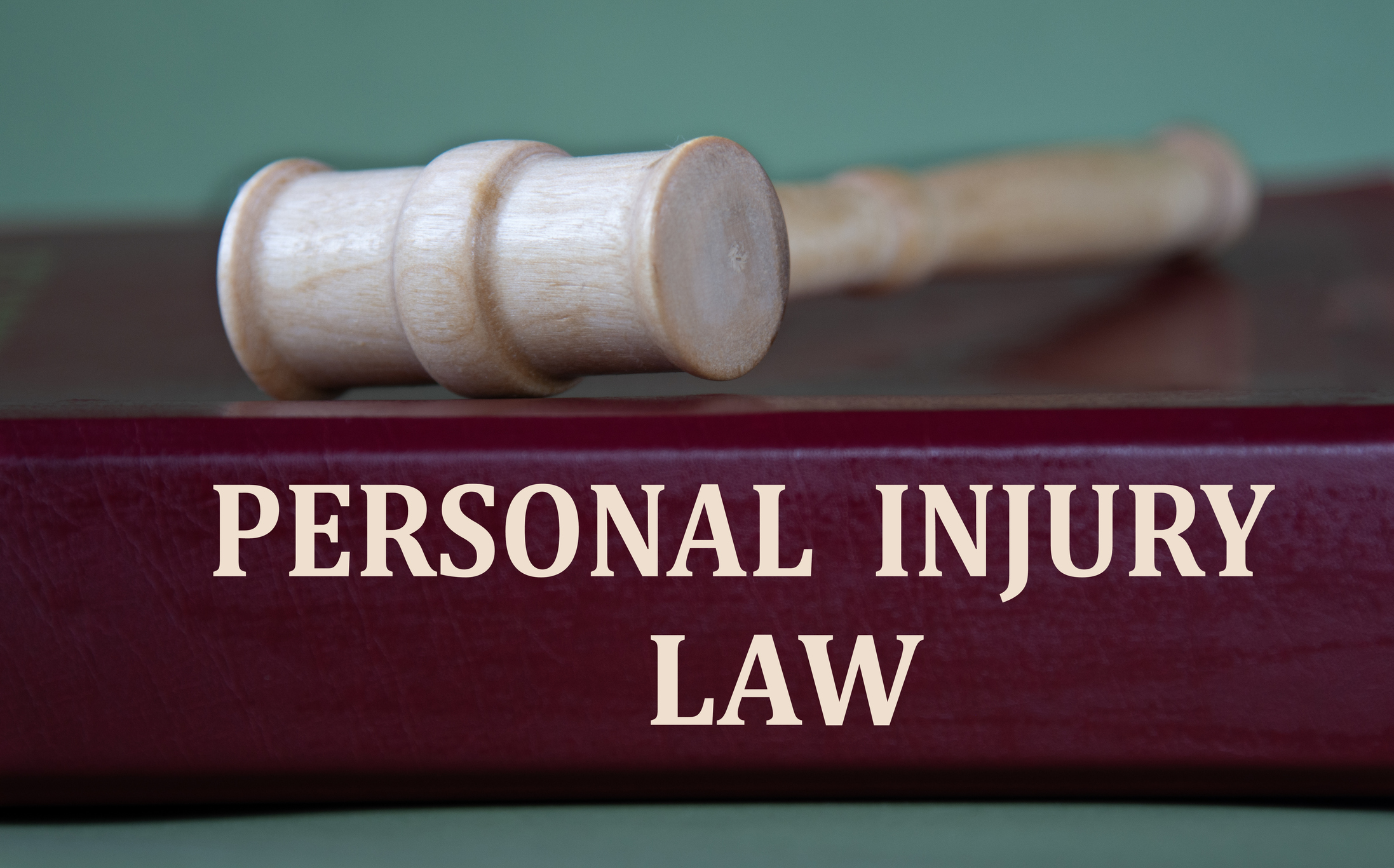 A book labelled “PERSONAL INJURY LAW” with a gavel atop it.